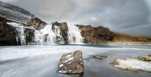 Scenic view of waterfall against sky