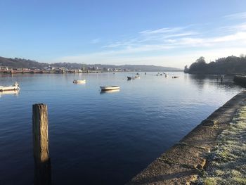 Boats moored in sea against sky