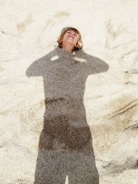 Woman with shadow buried in sand