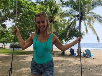 Portrait of smiling young woman standing on beach