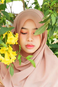 Close-up of young woman holding flower