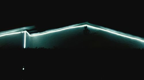 Close-up of illuminated lighting equipment against black background