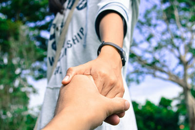 Cropped woman holding man hand