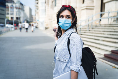 Young woman standing on street in city