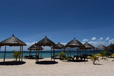 Deck chairs on beach against clear blue sky