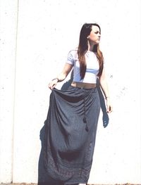 Young woman standing against white wall