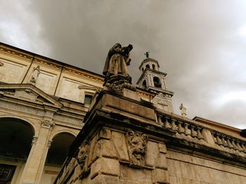 Low angle view of statue of historical building against cloudy sky