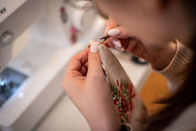 Cropped hand of woman applying nail