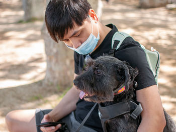 Rear view of man holding dog