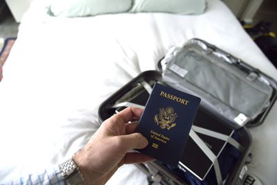 Cropped hand of man holding passport in room