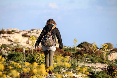 Rear view of woman standing on field