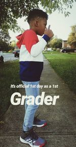 Full length of boy standing by text on plant