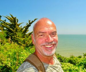 Portrait of smiling man mature man with sea in background