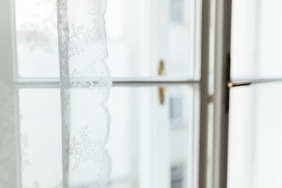 Close-up of curtain against window at home