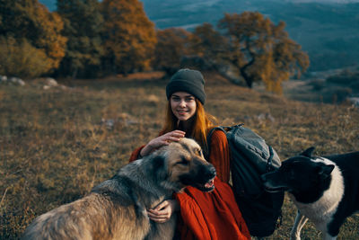 Woman with dog against trees