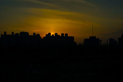 Silhouette buildings against sky during sunset