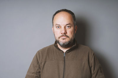 Portrait of man standing against white background