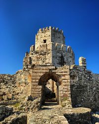 Low angle view of old building against clear blue sky