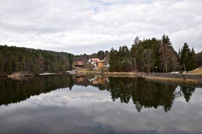 Scenic view of lake surrounded by trees against sky