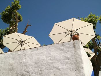 Low angle view of parasols on house against clear sky