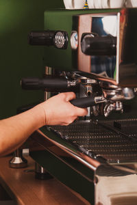 Close-up of man using coffee machine