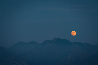 Scenic view of mountains against clear sky at dusk