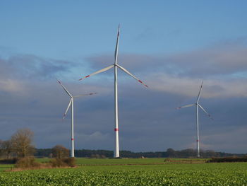 Windmill on field against sky