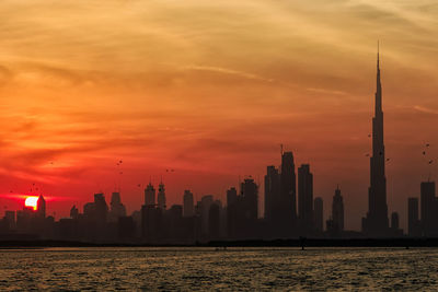 Scenic view of buildings against sky during sunset