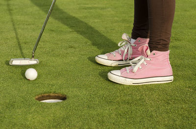 Low section of woman standing on golf course