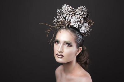 Close-up portrait of young fashion model against black background