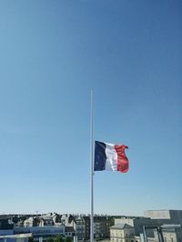 Low angle view of flag against clear blue sky