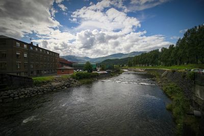 River amidst buildings in city against sky