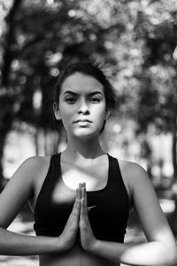 Portrait of teenage girl meditating while standing in park