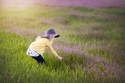 Rear view of woman standing on grassy field