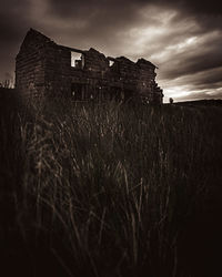 Abandoned house on field against sky