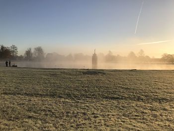 Scenic view of field against sky during foggy weather