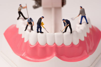 Miniature men working on dentures