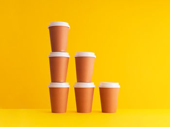 Close-up of coffee cup against yellow background