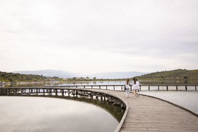 Rear view of people on lake against sky