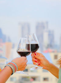 Cropped hand holding red wineglass