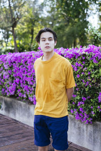 Portrait of boy standing on purple flowering plants