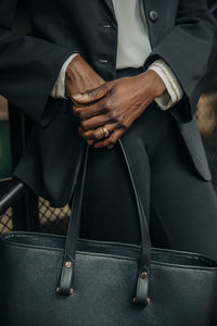 Midsection of young businesswoman holding bag