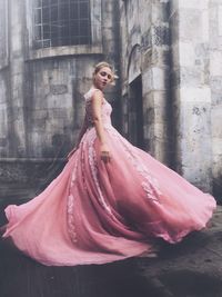 Portrait of woman standing against wall