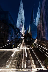 Double exposure of light trails on road and buildings in city at night
