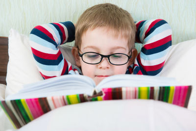 Cute boy holding thermometer in mouth at home