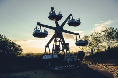 Empty ferris wheel against sky during sunset