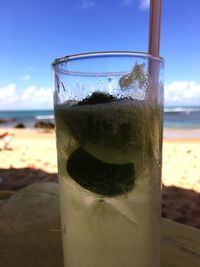 Close-up of drink in glass on beach