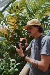 Side view of young man photographing plants