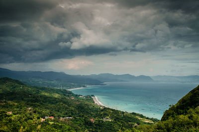 Scenic view of sea and mountains against sky