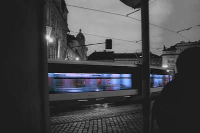 Train on illuminated city against sky at night